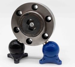 Ein silberner Metallflansch mit Bohrungen steht auf einem schwarzen und einem blauen Stützfuß vor hellem Hintergrund.